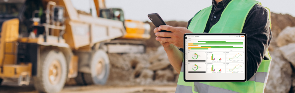 COINS construction software on a tablet with a construction site and person holding a smart phone in the background.